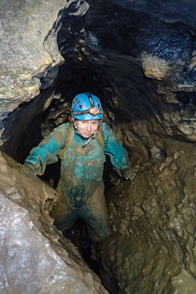 Larzelere crawling through cave passage