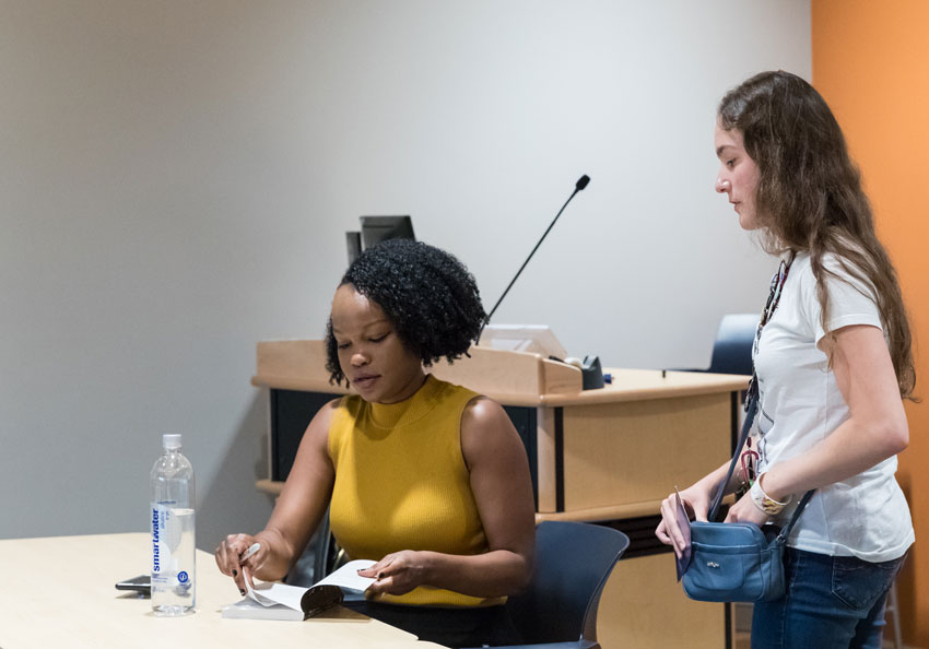 Nafissa Thompson-Spires signing a book for a student