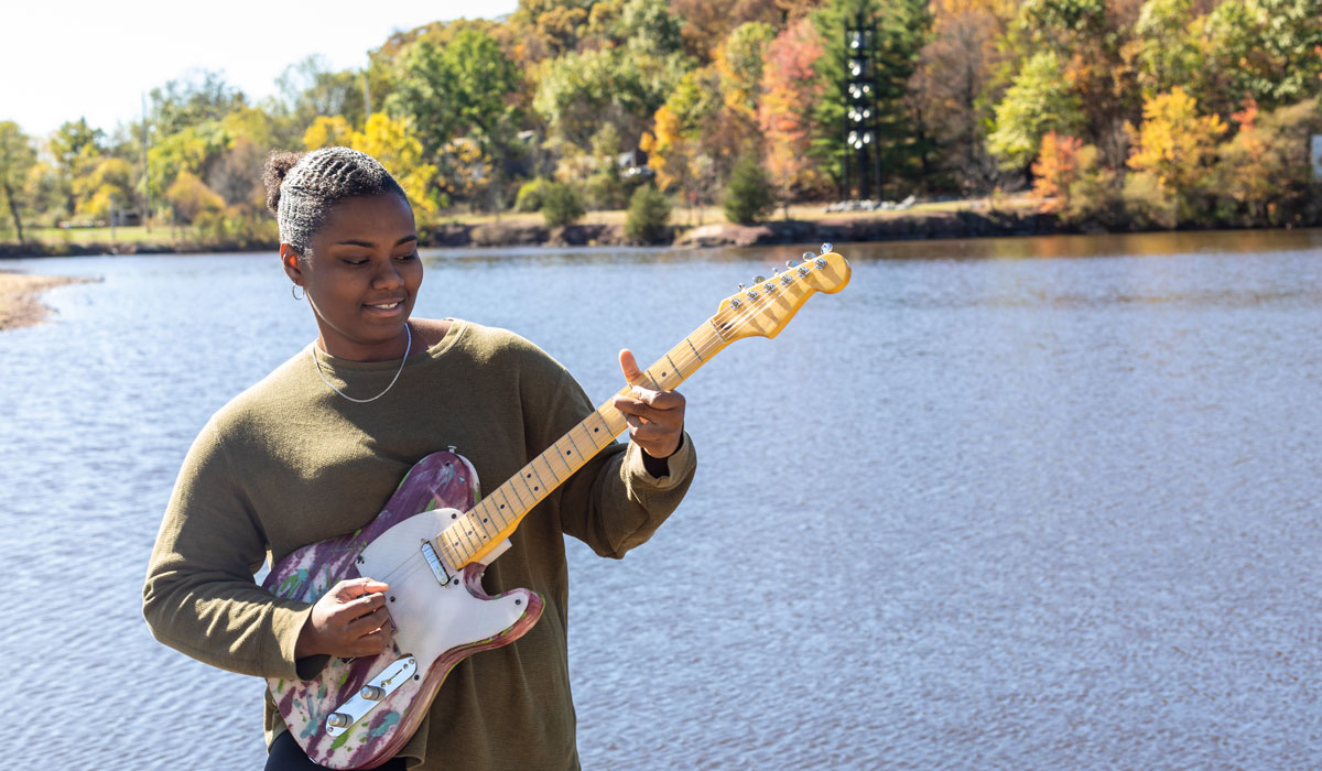Lamara White outside with her 3D printed guitar