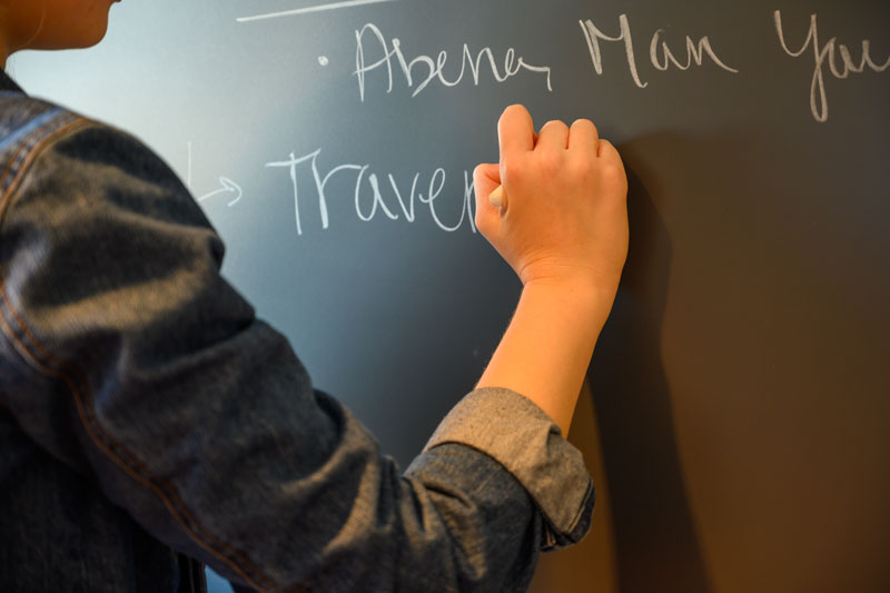 Caroline Cuetara writing on a chalkboard