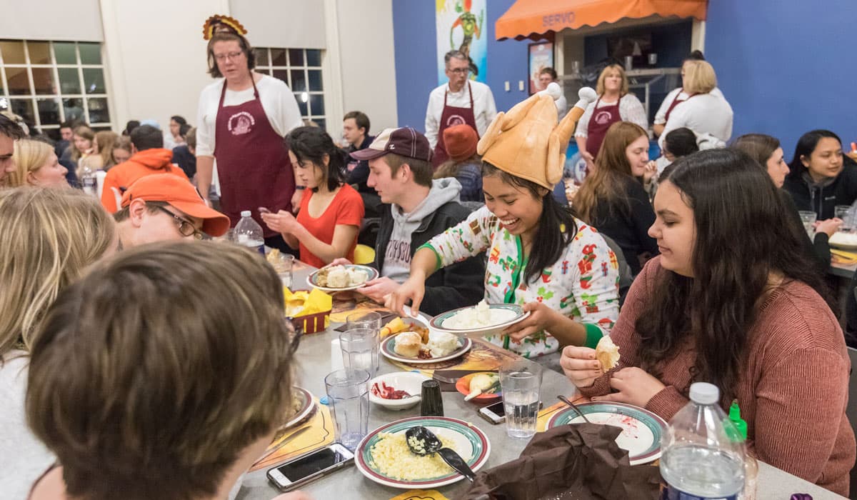 Student wearing a turkey hat at servo Thankgiving