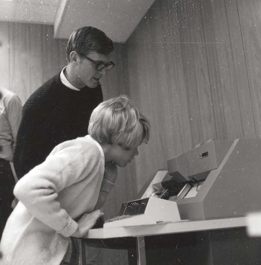Man and woman leaning over to look at computer screens