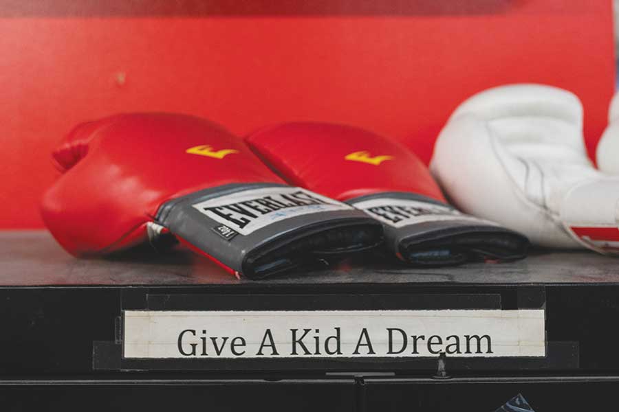 Boxing gloves on a shelf with the label Give a Kid A Dream