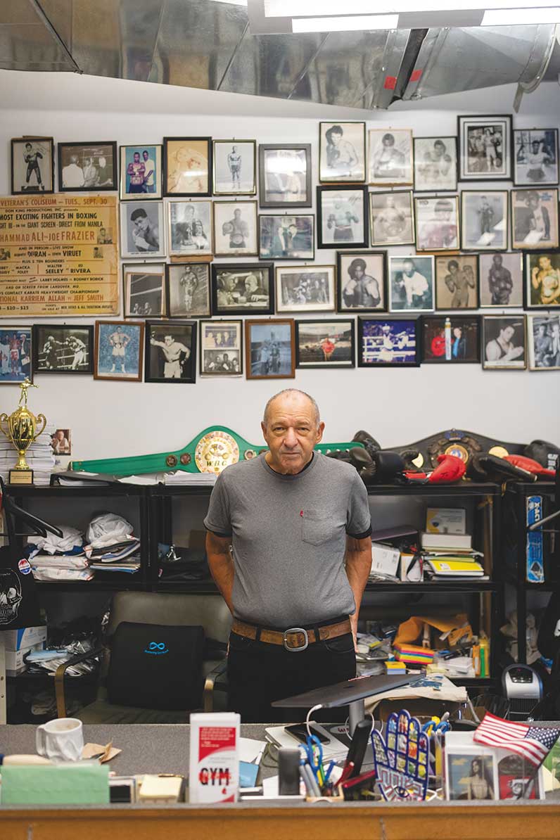 Bruce Silverglade in his office with a wall of framed photos behind him