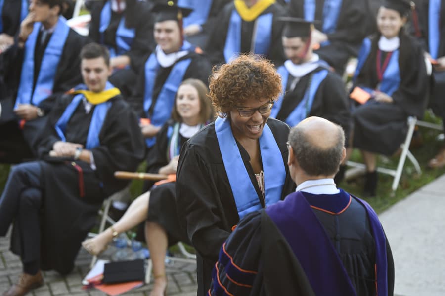 A graduate shakes hands with President Bob Iuliano