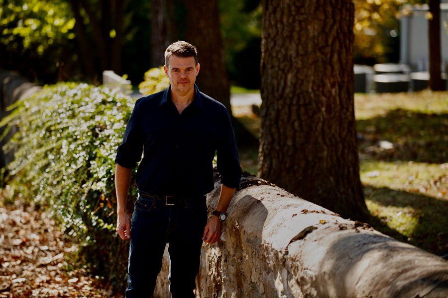 Jim Downs standing outside near a stone wall