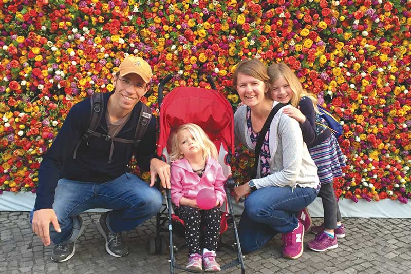 Shelli Frey with her family in front of a colorful wall of tulips