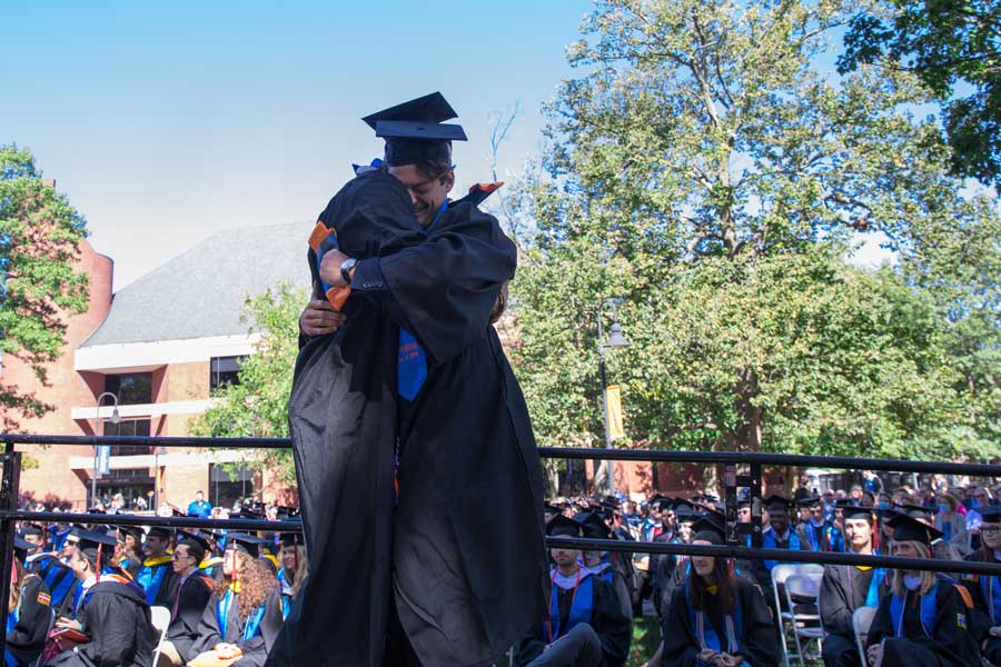 Two graduates hugging one another