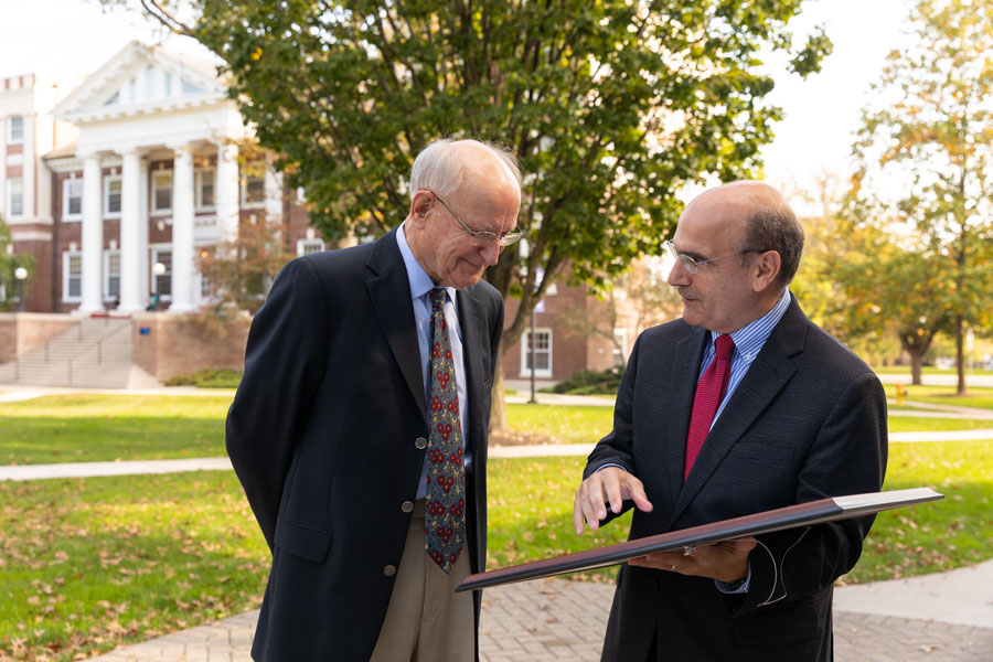 Jim Apple speaking to Bob Iuliano who is holding a picture frame