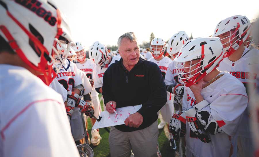 Gettysburg Lacrosse Coach with Lacrosse players gathered around him