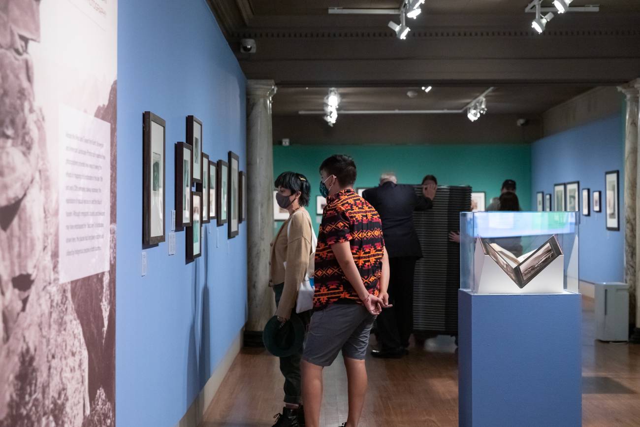 Attendees looking at pictures hung on a wall