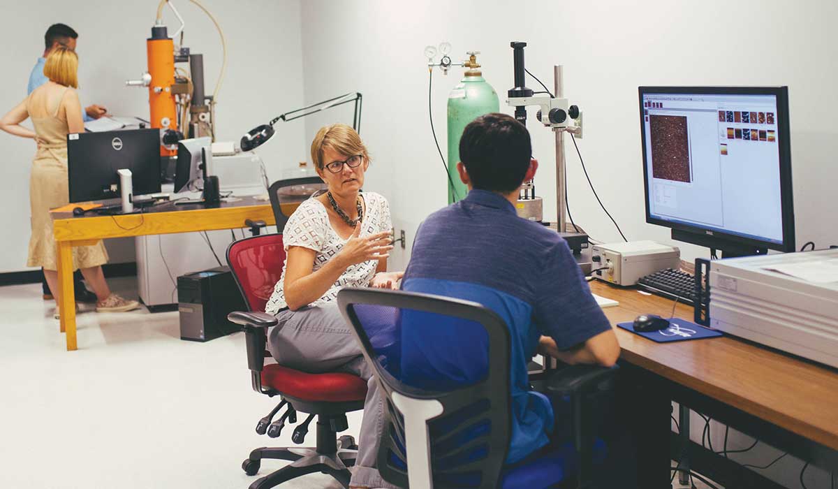 Shelli Frey in a lab with a student sitting in front of a computer