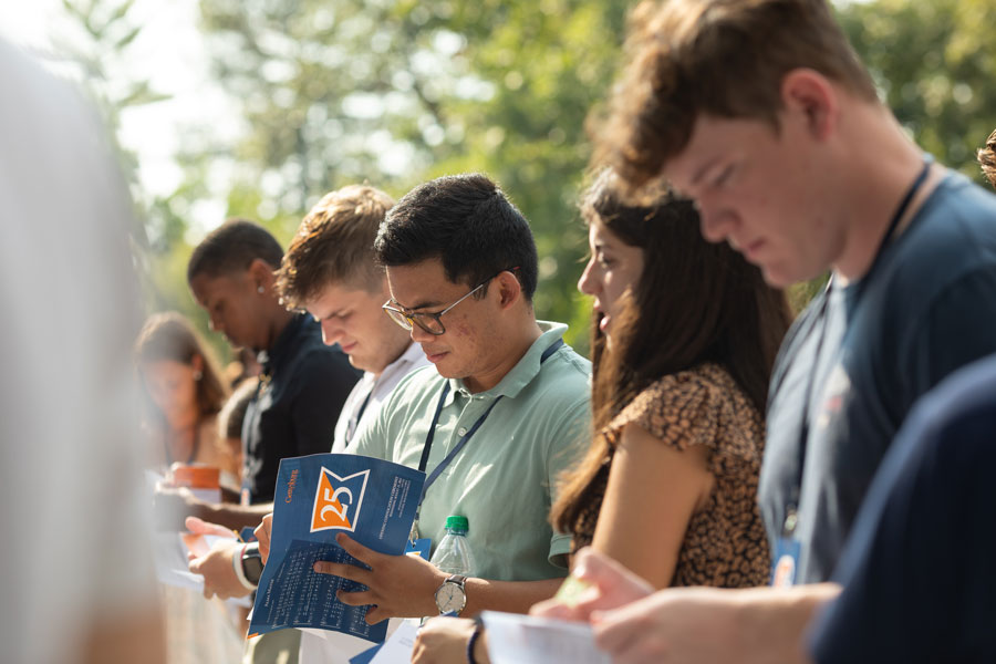 Students standing and looking at their convocation booklets