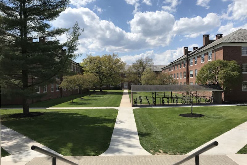 West Quad interior with green grass and puffy clouds in a blue sky