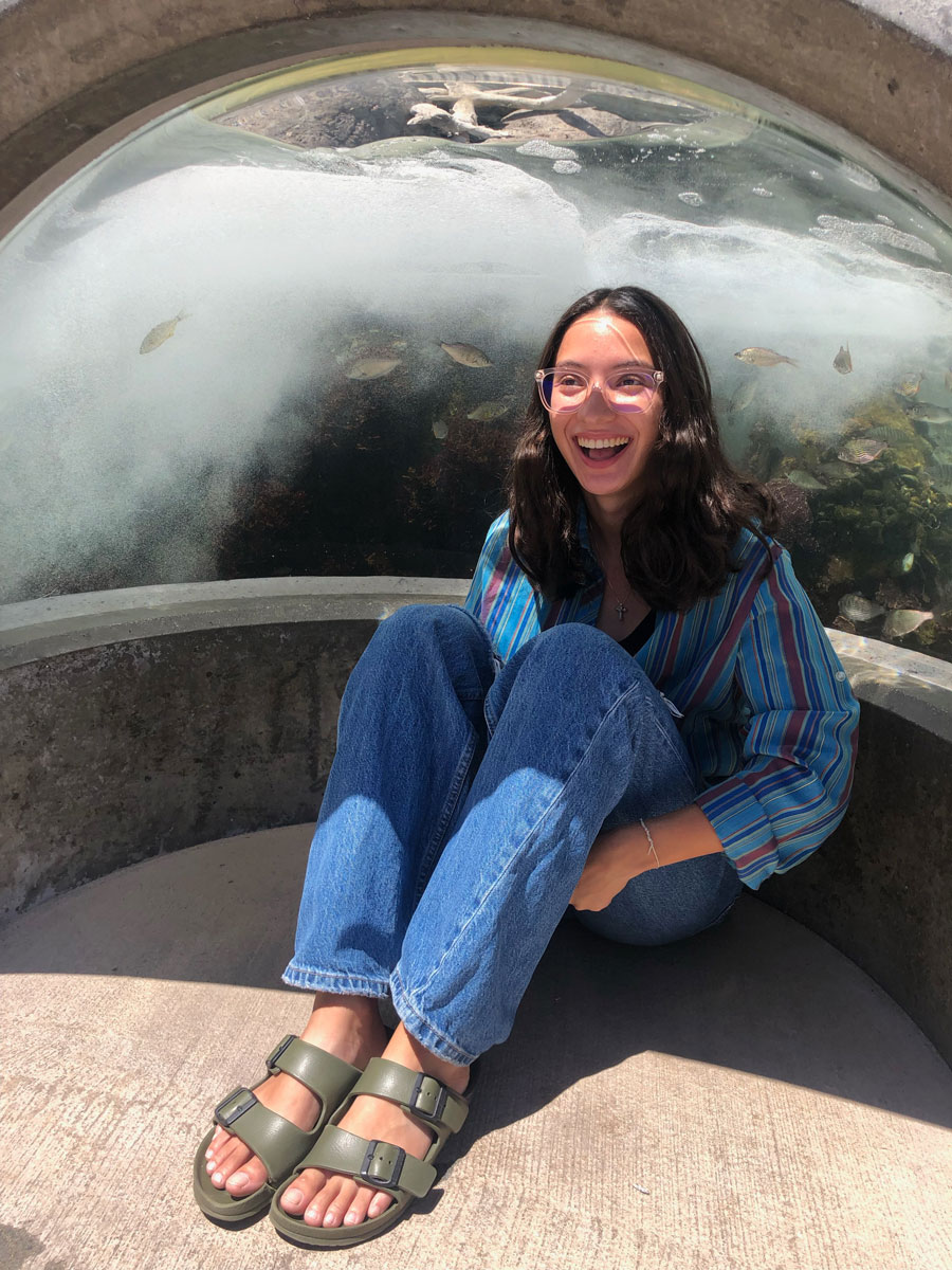 Adriana sitting in front of a reflective surface