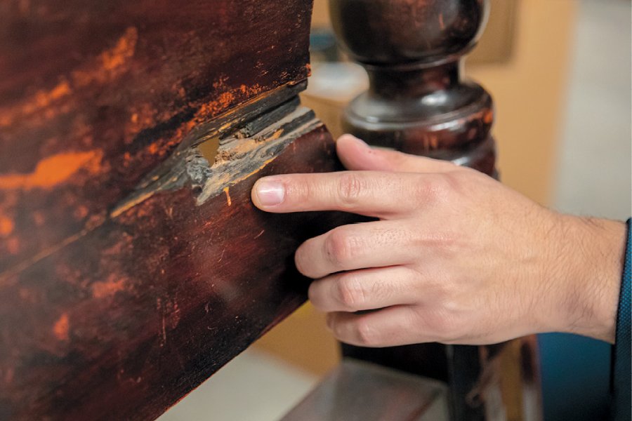 Andrew points out a bullet hole in a head board