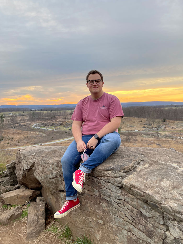 Brandon sitting on a rock