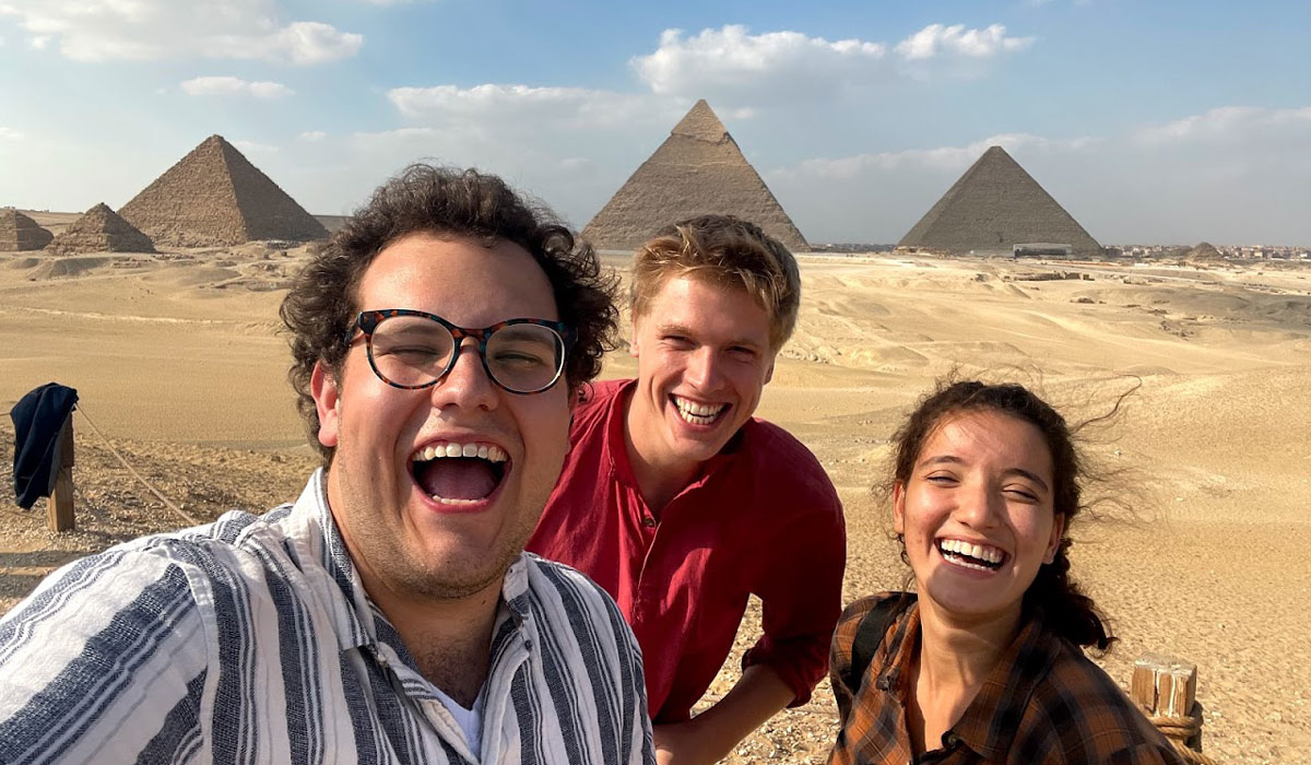 Brandon posing with friends in front of the Egyptian Pyramids