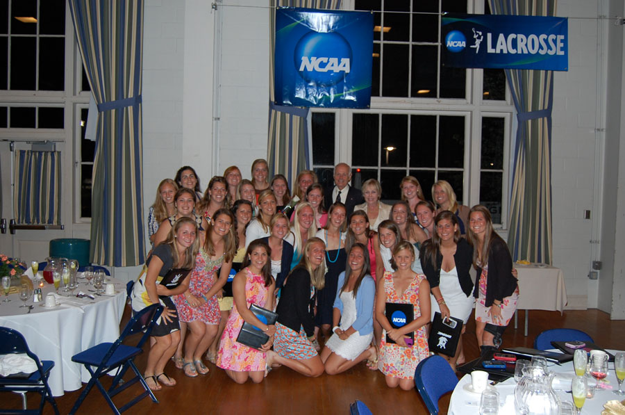 John Clark posing with Womens Lacrosse team