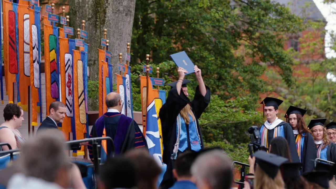 Graduate holding diploma at Commencement