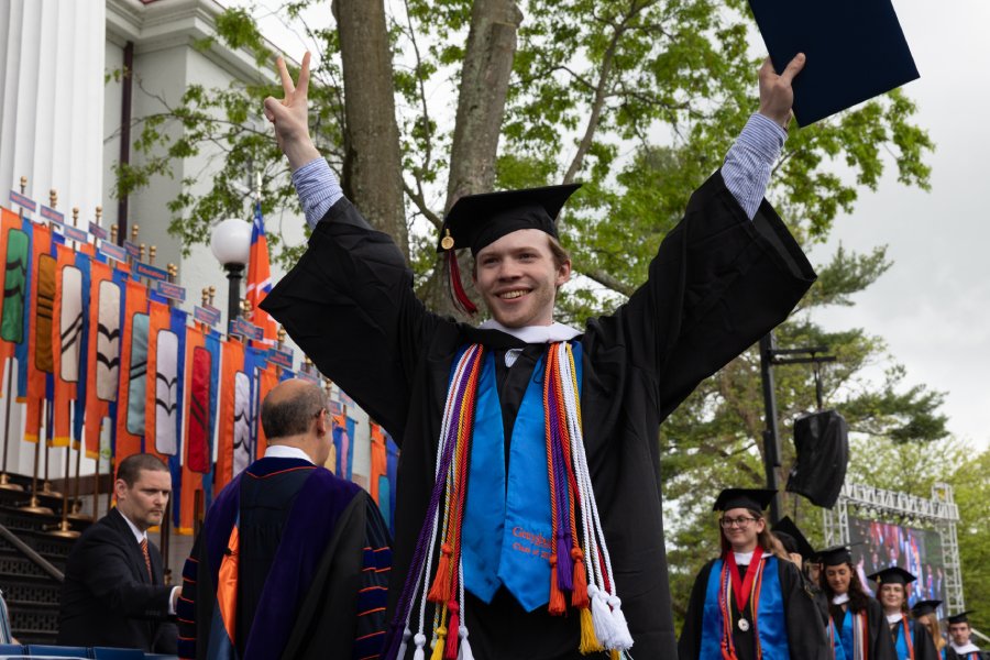 A graduate raising up his hands