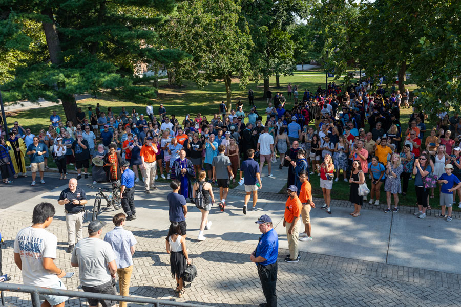 Students crowded behind Penn Hall and walking down a path together