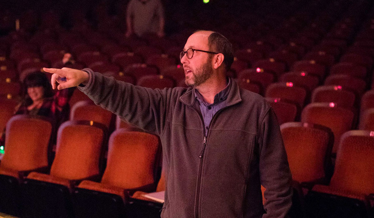 Chris Kauffman pointing inside a theatre