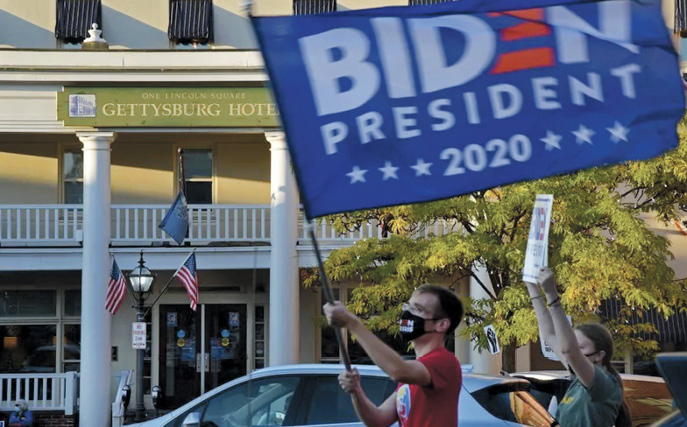 Douglas Page waving a President Joe Biden flag in the square of Gettysburg, PA