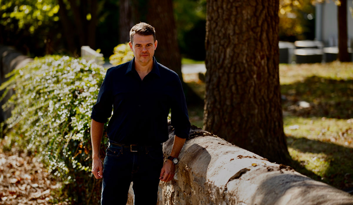 Jim Downs standing outside near a stone wall