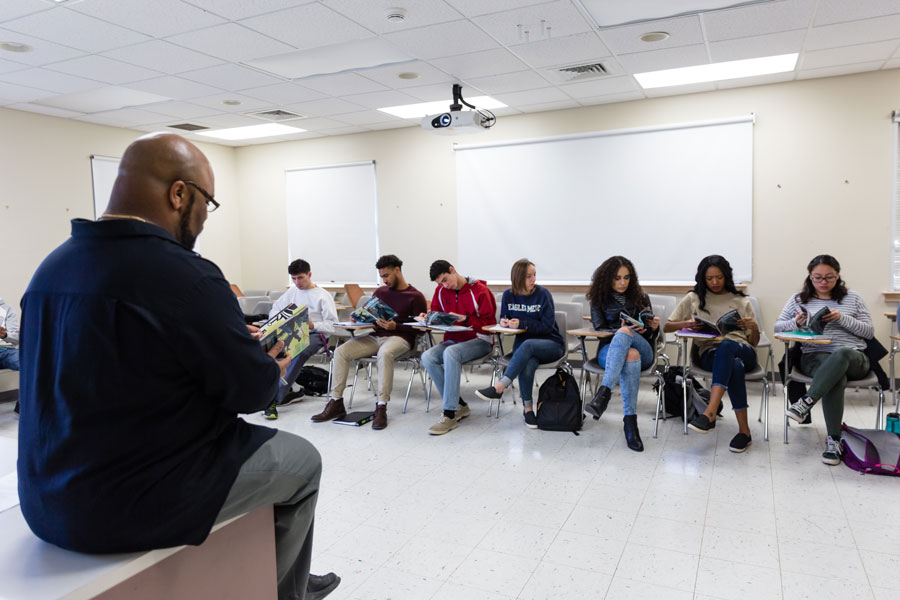 Students sitting at their desks inside a white classroom setting