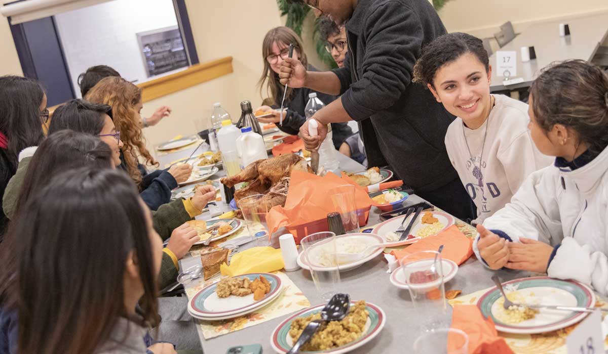 Students sitting at a table and eating at Servo Thanksgiving