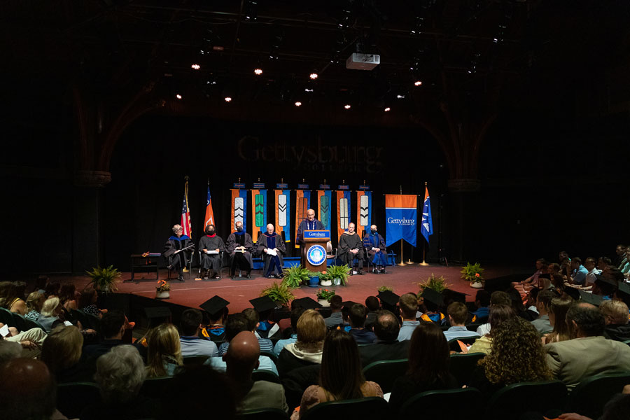 Bob Iuliano speaking from a podium on an indoor stage