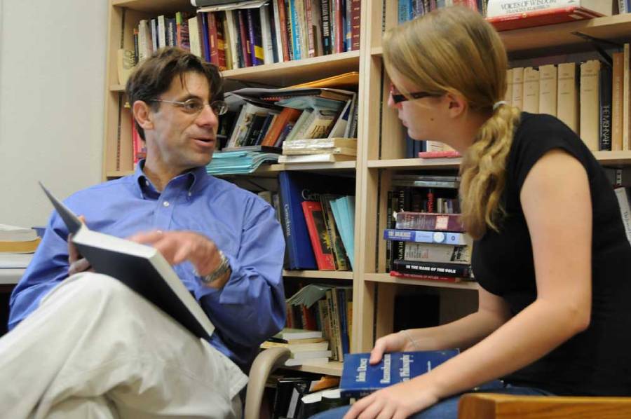 Jewish Studies Prof. Stephen Stern holding a book and talking to a woman