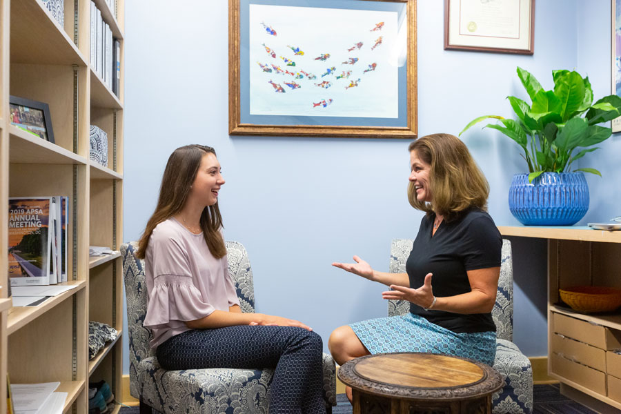 Student and teacher talking to one another while sitting down