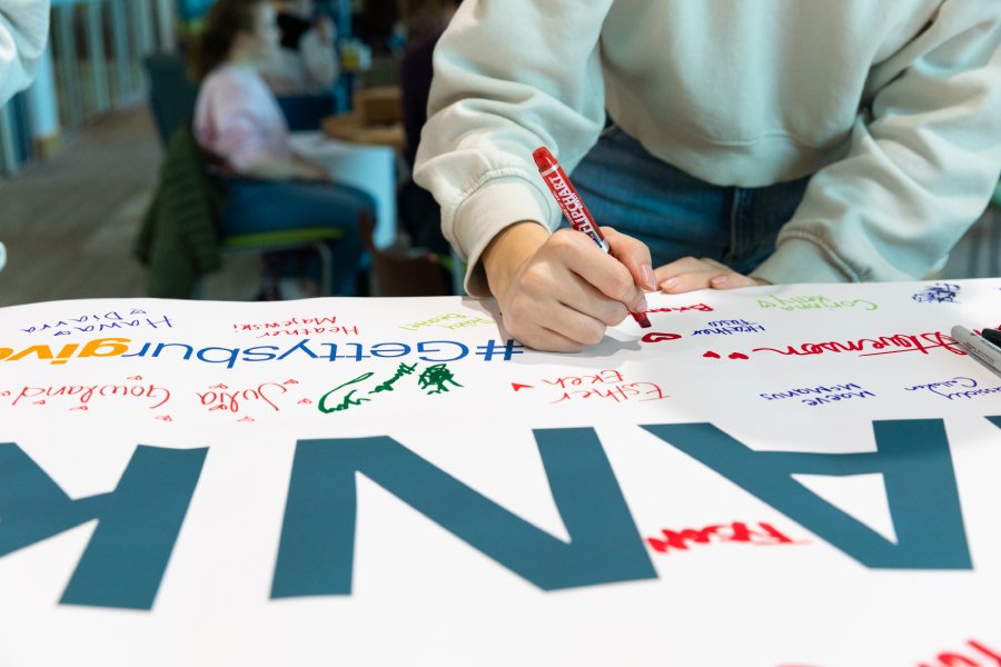 Student signs on banner