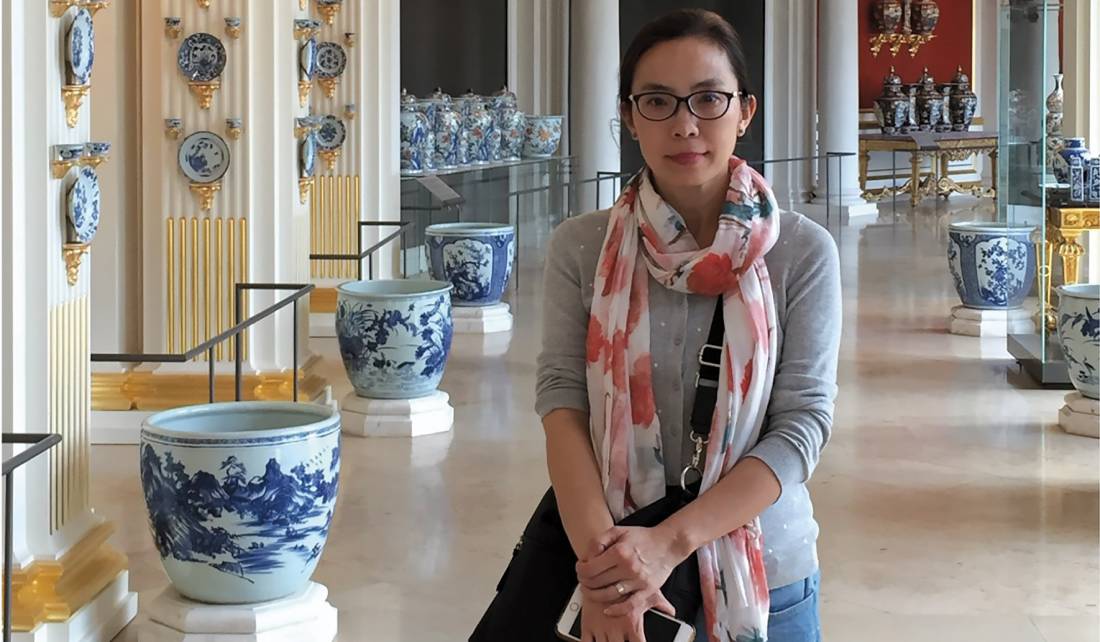 Yan Sun at a museum with asian pottery behind her in the background