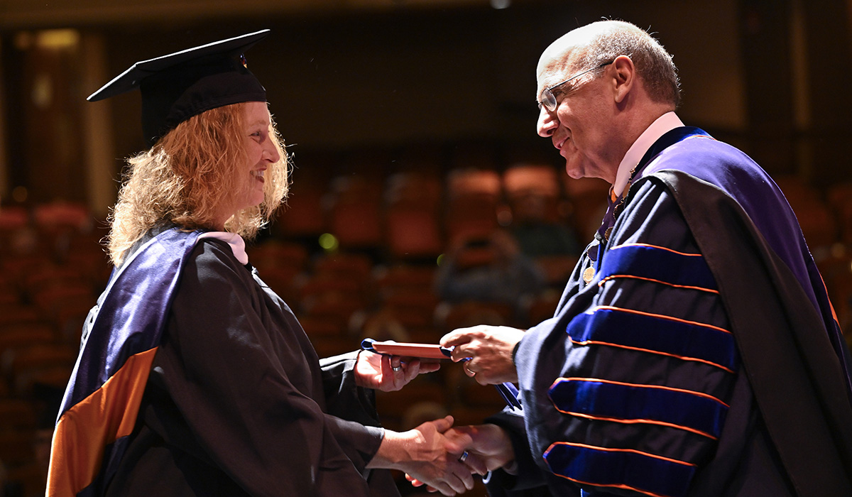 Gettysburg College President Bob Iuliano presents a Stole of Gratitude to a graduate 