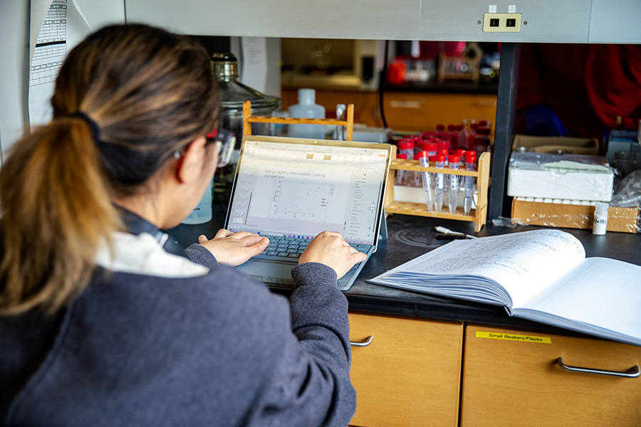 A student typing on the computer