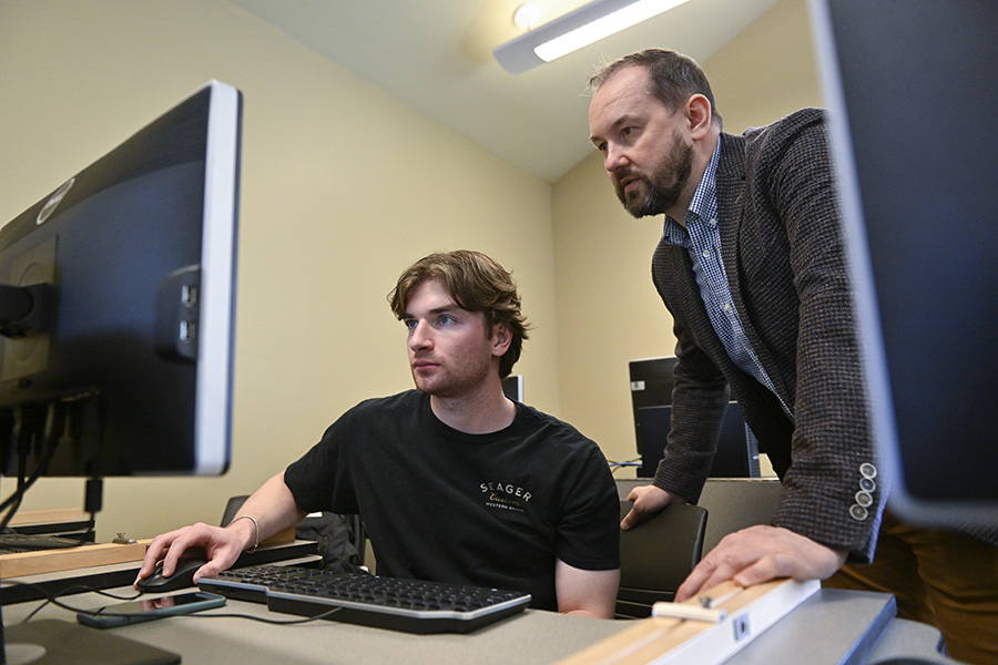 A student and professor looking at a monitor