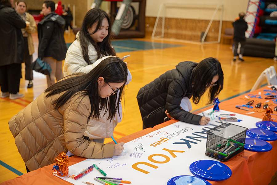 Students signing a thank you banner at the festival 