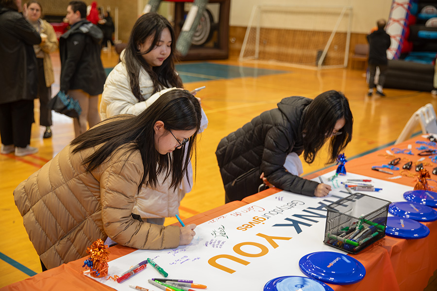 Students signing a thank you banner at the festival