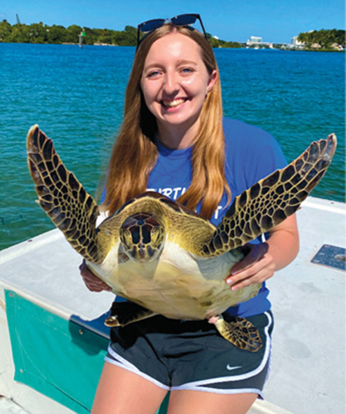 Photograph of Bethany Holtz holding a large turtle