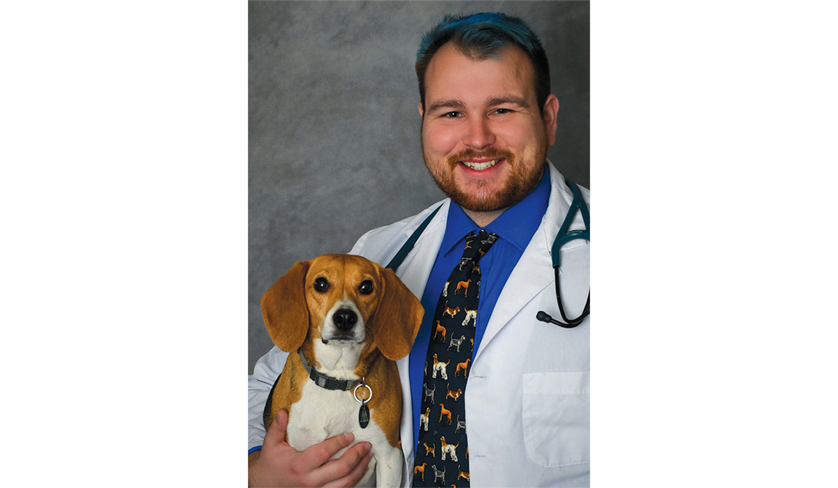 A photo of Dr. Mike Karchner ’19 holding his beagle, Hazel