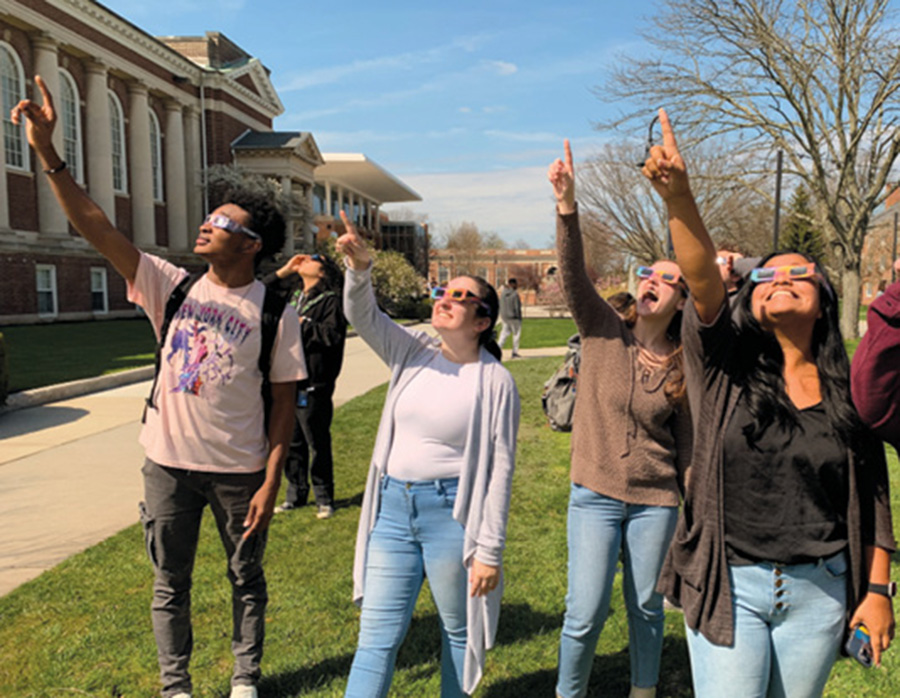 A photo of students pointing to the moon