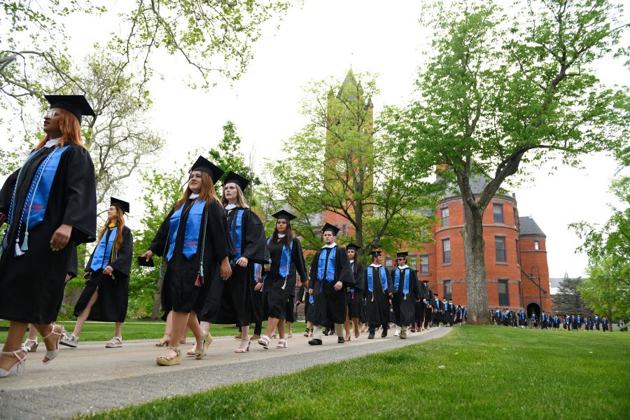 Graduates walk past Glatfelter Hall at Commencement.