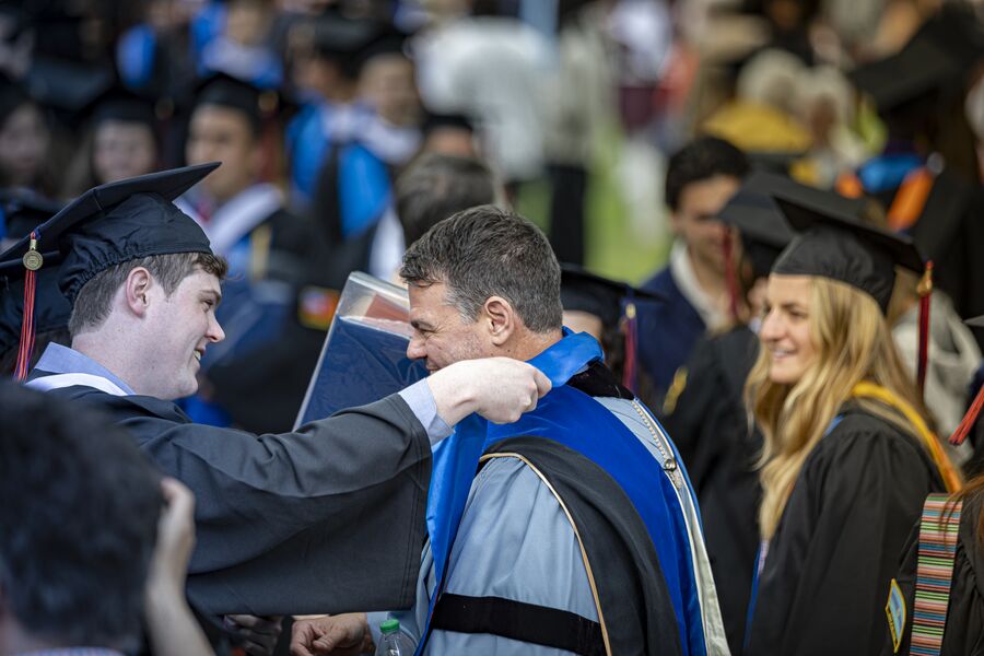 Prof. Downs being given a Stole of Gratitude by a graduate at the Class of 2024 Commencement ceremony.