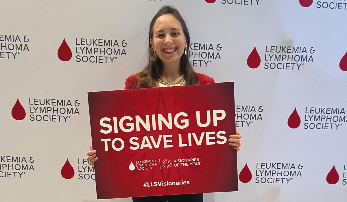 A photp of Elizabeth Foster ’15 holding a sign that reads