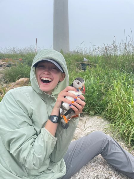 Jocelyn Little ’25 holds a seabird during research on Petit Manan Island, Maine.