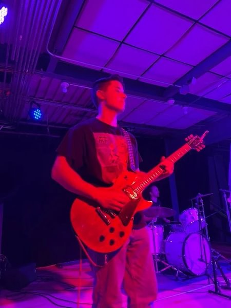 Nate Kong ’25 plays guitar for Listeners and Performers.