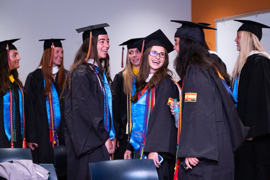 Softball seniors Alyna Balewitz and Carlie Goldstein laugh with lacrosse senior Izzy Chiperfield before Special Commencement.